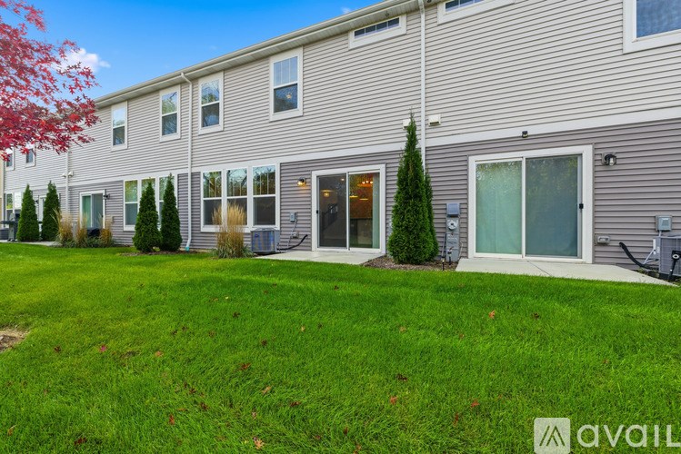 A building with a grey facade and a green lawn in front.