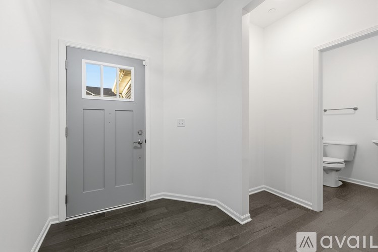 A bathroom with a toilet and a door leading to a balcony.
