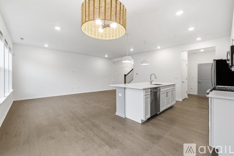 A modern kitchen with a wooden floor and white cabinets.
