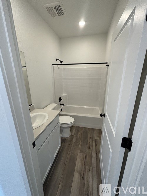 A bathroom with a toilet, sink, and shower.