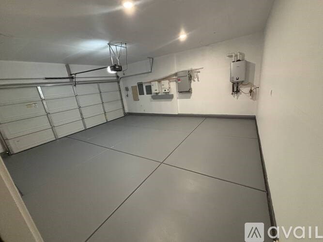 A spacious garage with a grey floor and white walls.