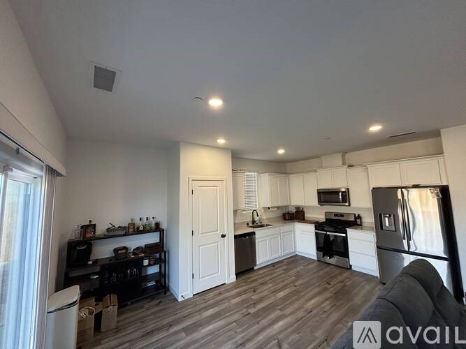 A kitchen with white cabinets and a wooden floor.