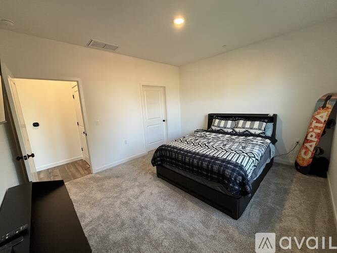 A bedroom with a bed, dresser, and a television.