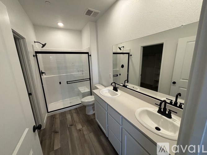 A bathroom with a toilet, sink, and shower.