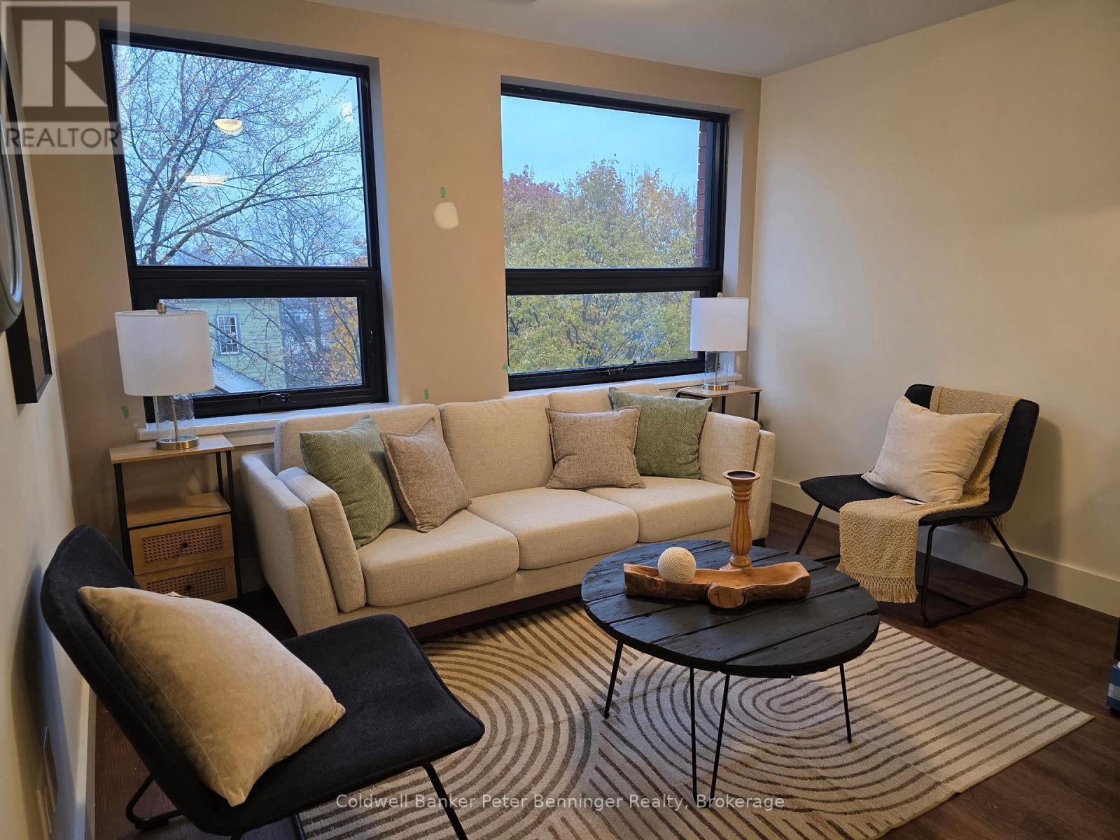 A living room with a white couch, a black chair, and a coffee table.