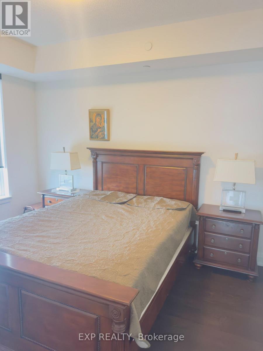 A bedroom with a bed, nightstand, and lamp.