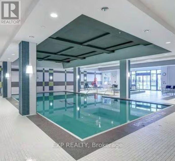 A large indoor swimming pool with a glass wall on one side.