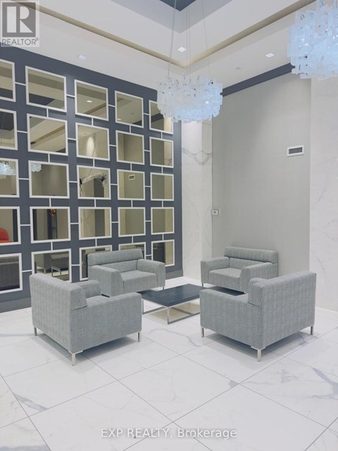 A living room with grey couches and a glass block wall.