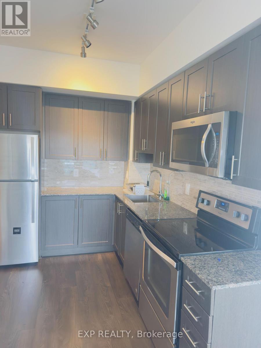 A kitchen with dark wood cabinets and stainless steel appliances.