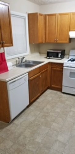 A kitchen with wooden cabinets and white appliances.