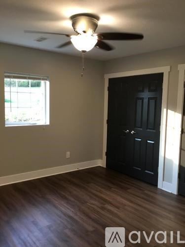 A room with a ceiling fan and a door.