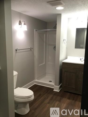 A bathroom with a toilet, sink, and shower.