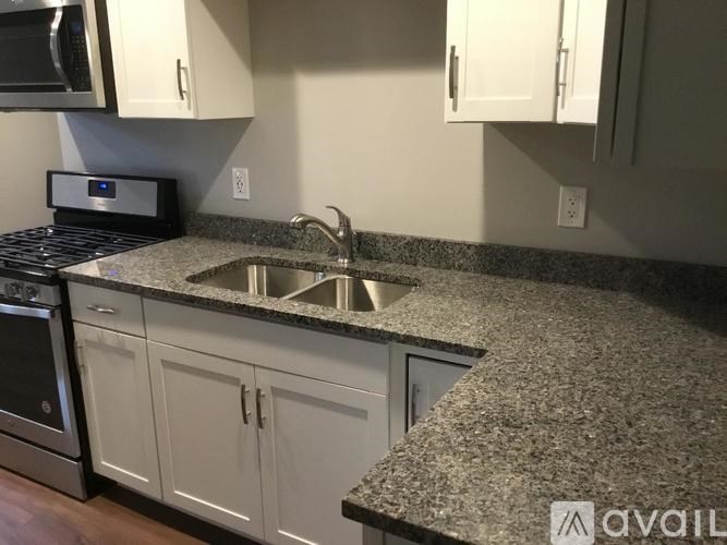 A kitchen with granite countertops and white cabinets.