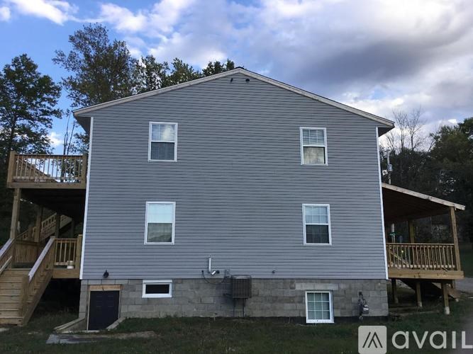 A house with a grey siding and a balcony on the second floor.