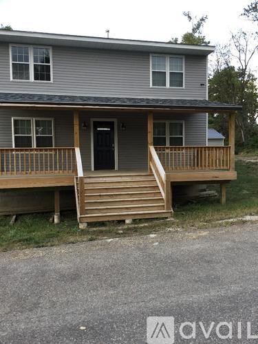 A house with a grey exterior and a wooden deck.