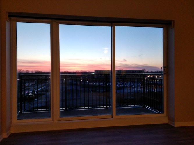 A view of a parking lot through a window at dusk.