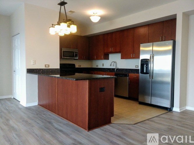 A kitchen with wooden cabinets and a black countertop.
