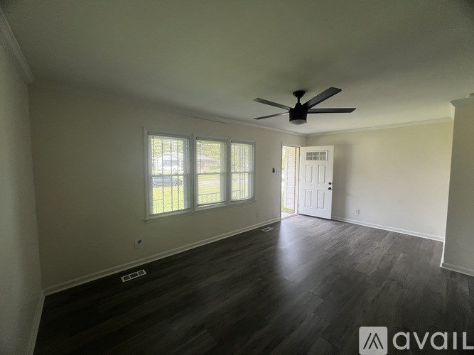 A spacious room with a ceiling fan and sliding glass doors.