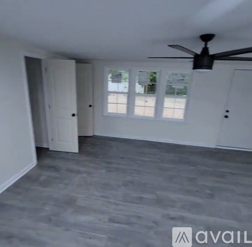 A room with a ceiling fan and a door.