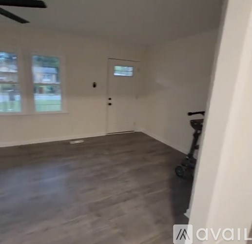 A room with a wooden floor and a window.
