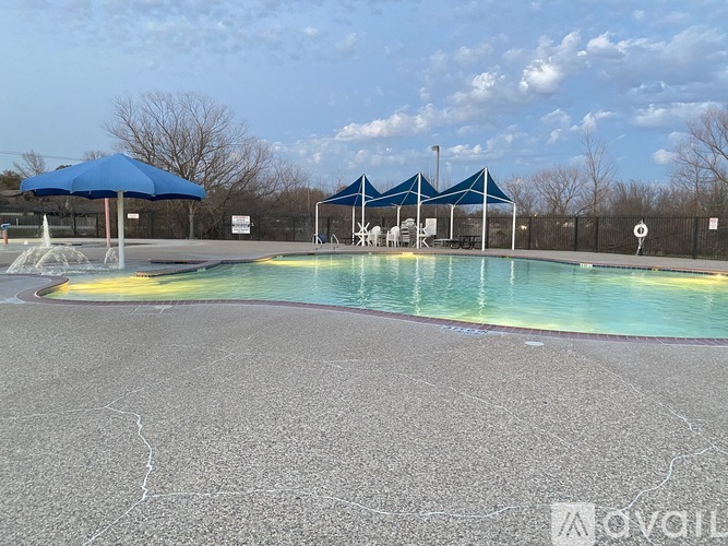 A pool with a blue umbrella and a white sign with a black border.