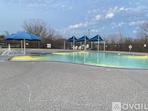 A pool with a blue umbrella and a white sign with a black border.