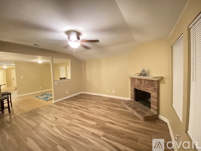A living room with a fireplace and wood flooring.