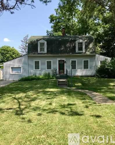 A white house with a green lawn in front.