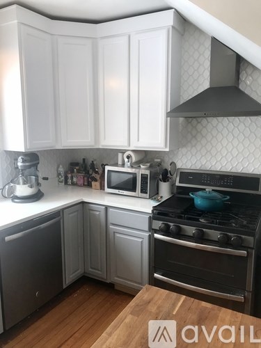 A kitchen with white cabinets and a black stove top.