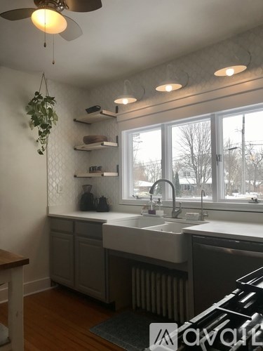 A kitchen with a white sink and a window.