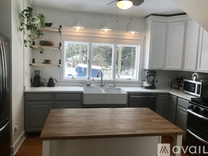 A kitchen with a wooden table in the middle of it.