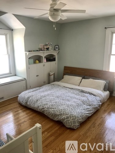 A bedroom with a bed, dresser, and window.