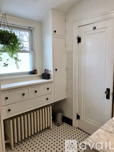 A white cabinet with a black handle is next to a white door.