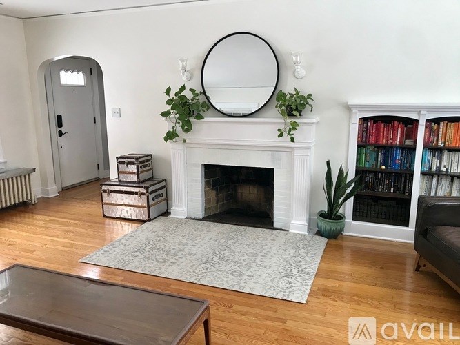 A living room with a fireplace, a mirror, a bookshelf, and a couch.