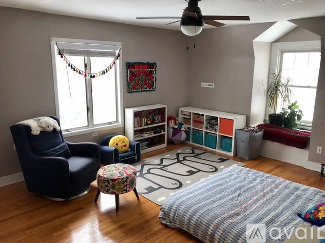 A living room with a blue chair and a yellow stuffed animal on it.