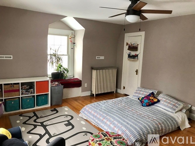 A bedroom with a bed, a ceiling fan, and a window.