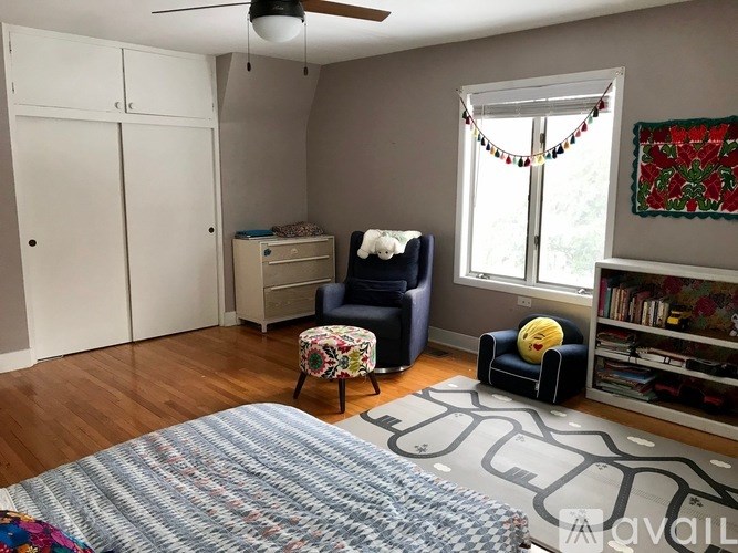 A room with a bed, a chair, a dresser, and a window.