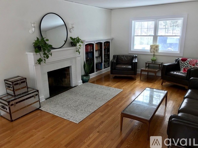 A living room with a fireplace and a mirror on the wall.