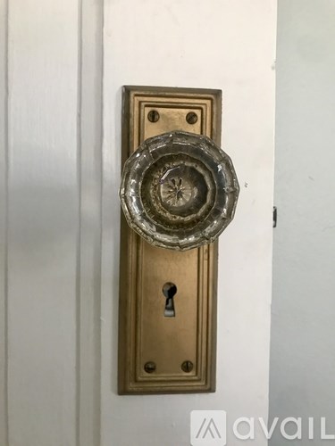 A door handle with a keyhole is mounted on a white door.