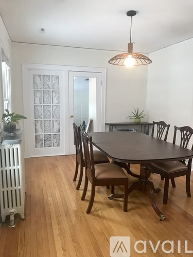 A dining room with a table and chairs.