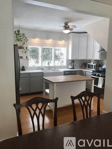 A kitchen with a table and chairs in front of it.