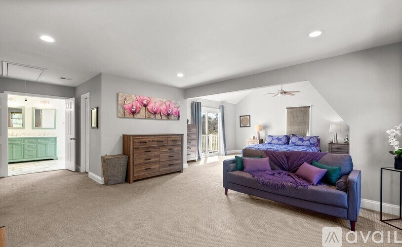 A bedroom with a bed, dresser, and ceiling fan.