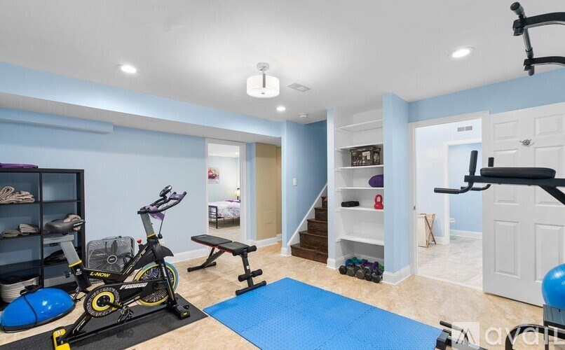 A room with a blue exercise mat and a stationary bike.