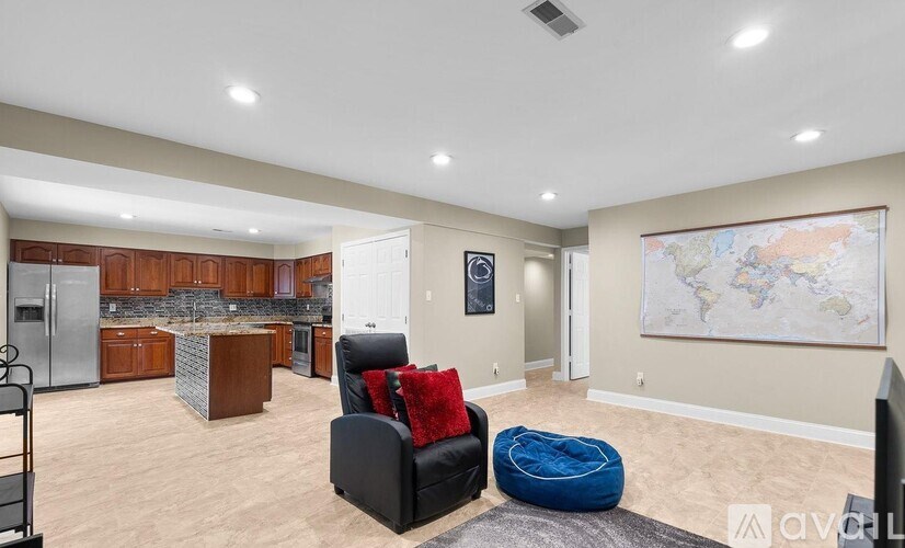 A living room with a black chair and a blue ottoman.