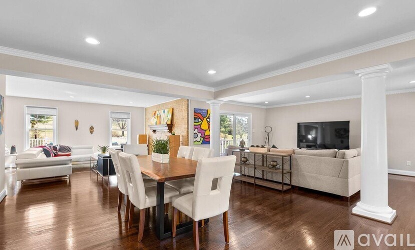 A spacious living room with a dining table and chairs.