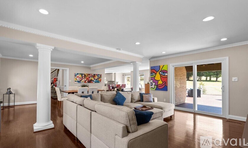 A living room with a large couch and a painting on the wall.