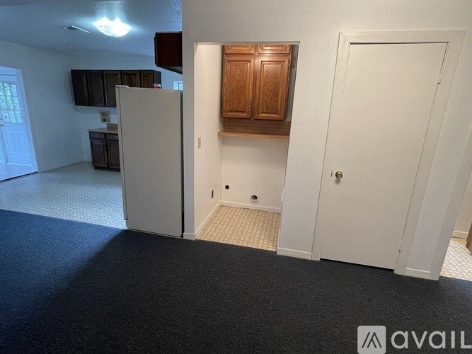 A room with a white door, a white cabinet, and a white wall.