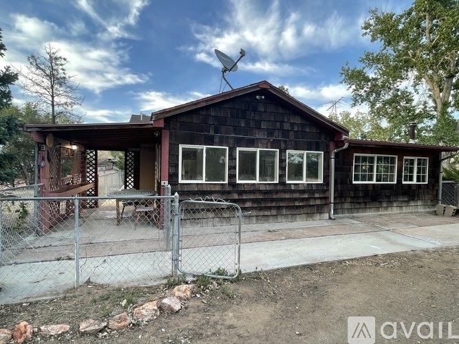 A wooden house with a satellite dish on the roof.