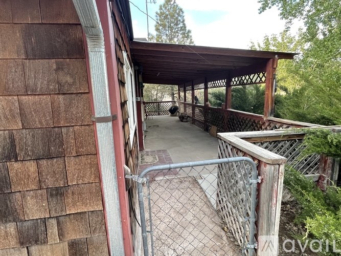 A wooden building with a metal gate in front.