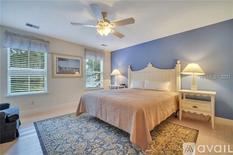 A bedroom with a bed, nightstand, and window with blinds.